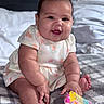 adorable, baby, bed, blanket, child, chubby, clothing, cute, face, hair, happy, indoors, infant, pink, playful, sitting, skin, smiling, toy, young