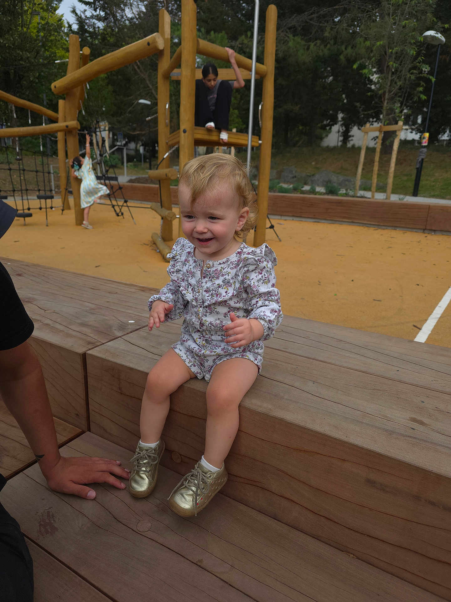 Nya participe au concours pour gagner de l'argent avec cette photo : toddler, child, playground, wood, bench, outdoor, clothing, shoes, smile, person, play, fun, park, wooden_structure, trees, daylight, happy, casual, young_child, activity