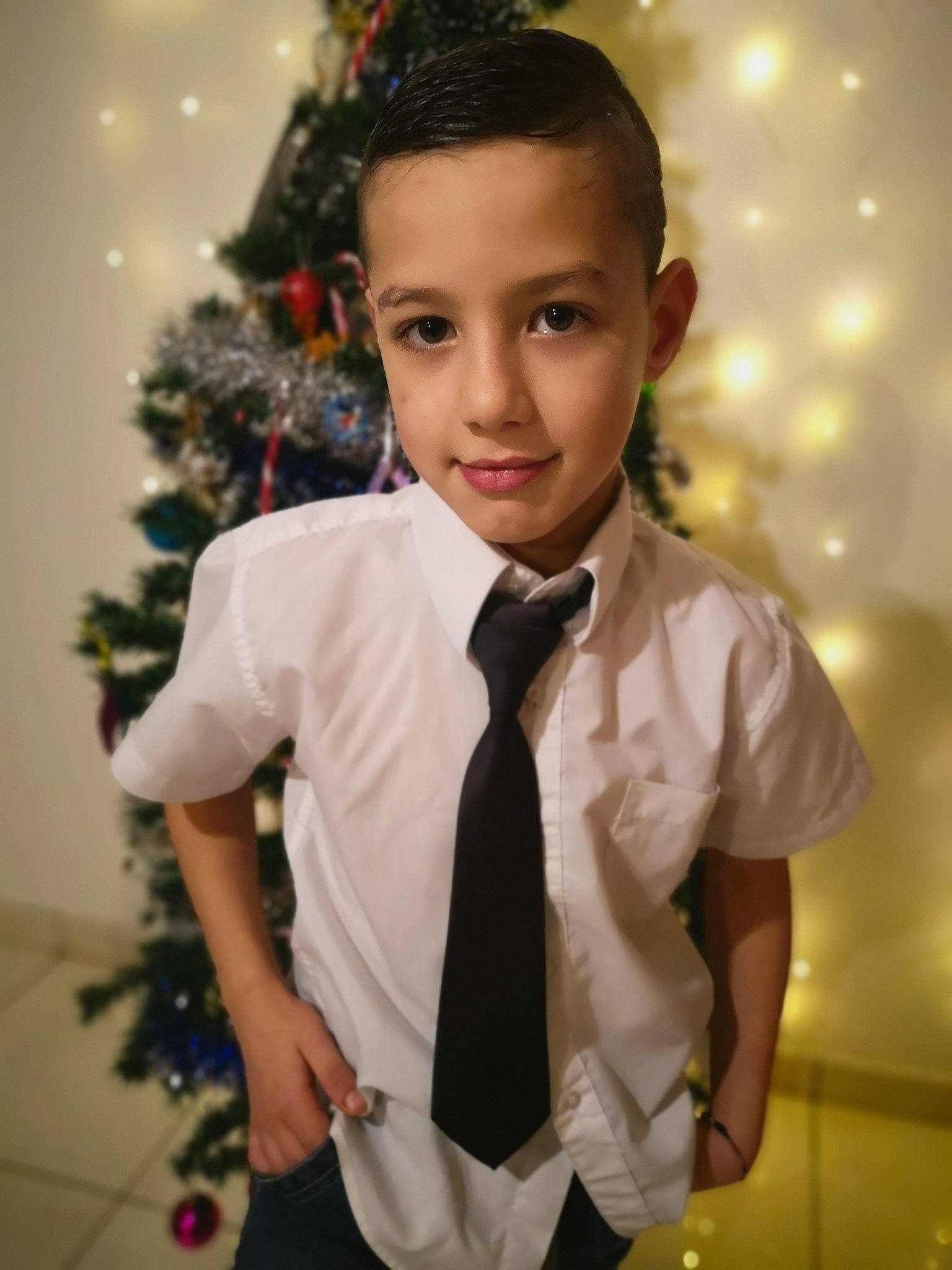 Owen a rejoint le concours — aidez-le/la à gagner de superbes lots ! bow_tie, ceremony, child, child_model, christmas, formal_wear, happy, holiday, joy, outerwear, person, plant, smile, suit, tie, toddler, tuxedo, white