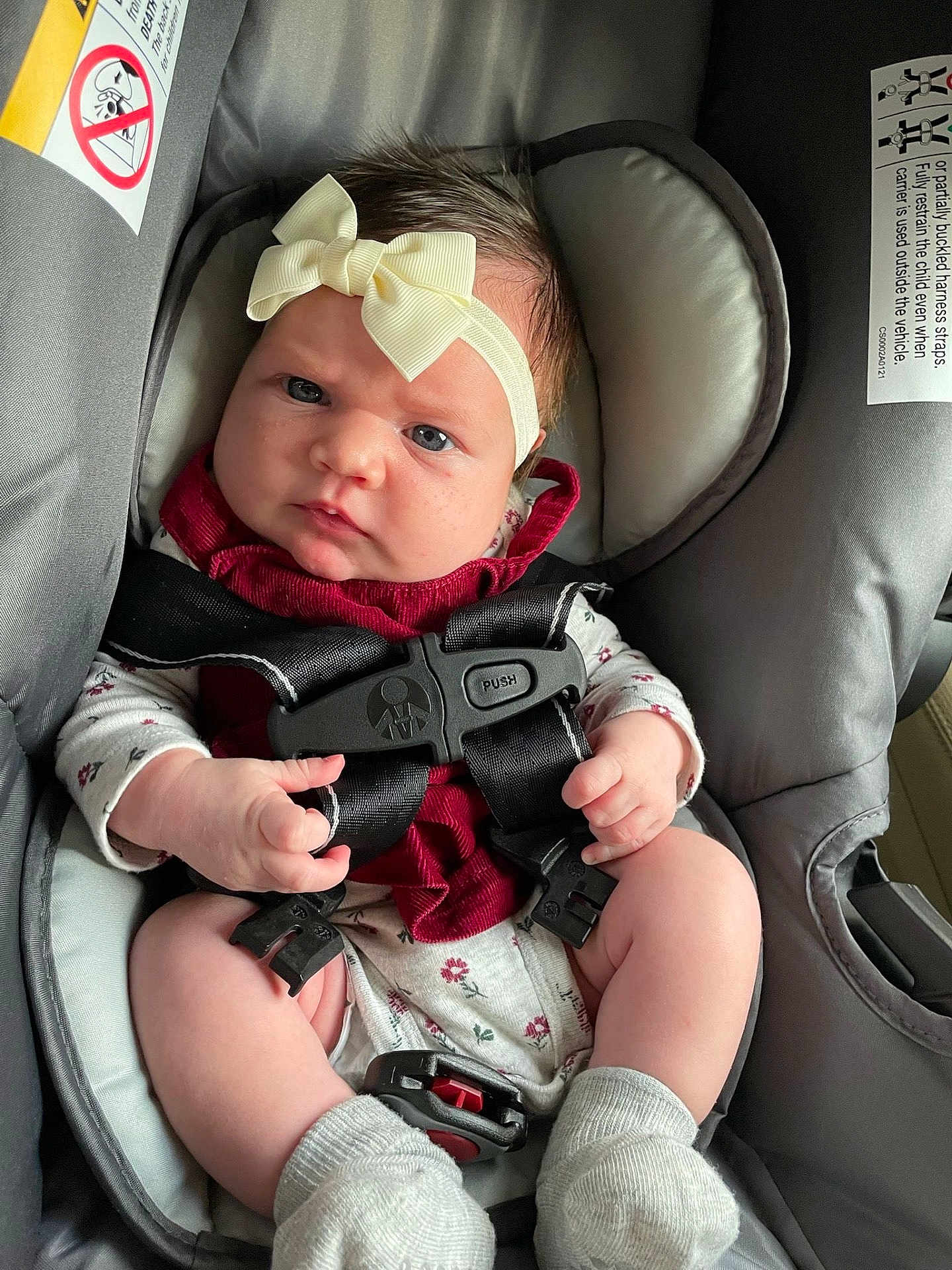 Amirah is registered to the contest to win money with this photo: baby, car_seat, infant, headband, bow, harness, clothing, socks, face, hands, seat, child, infant_clothing, baby_girl, car_safety, straps, closeup, indoor, expression, person