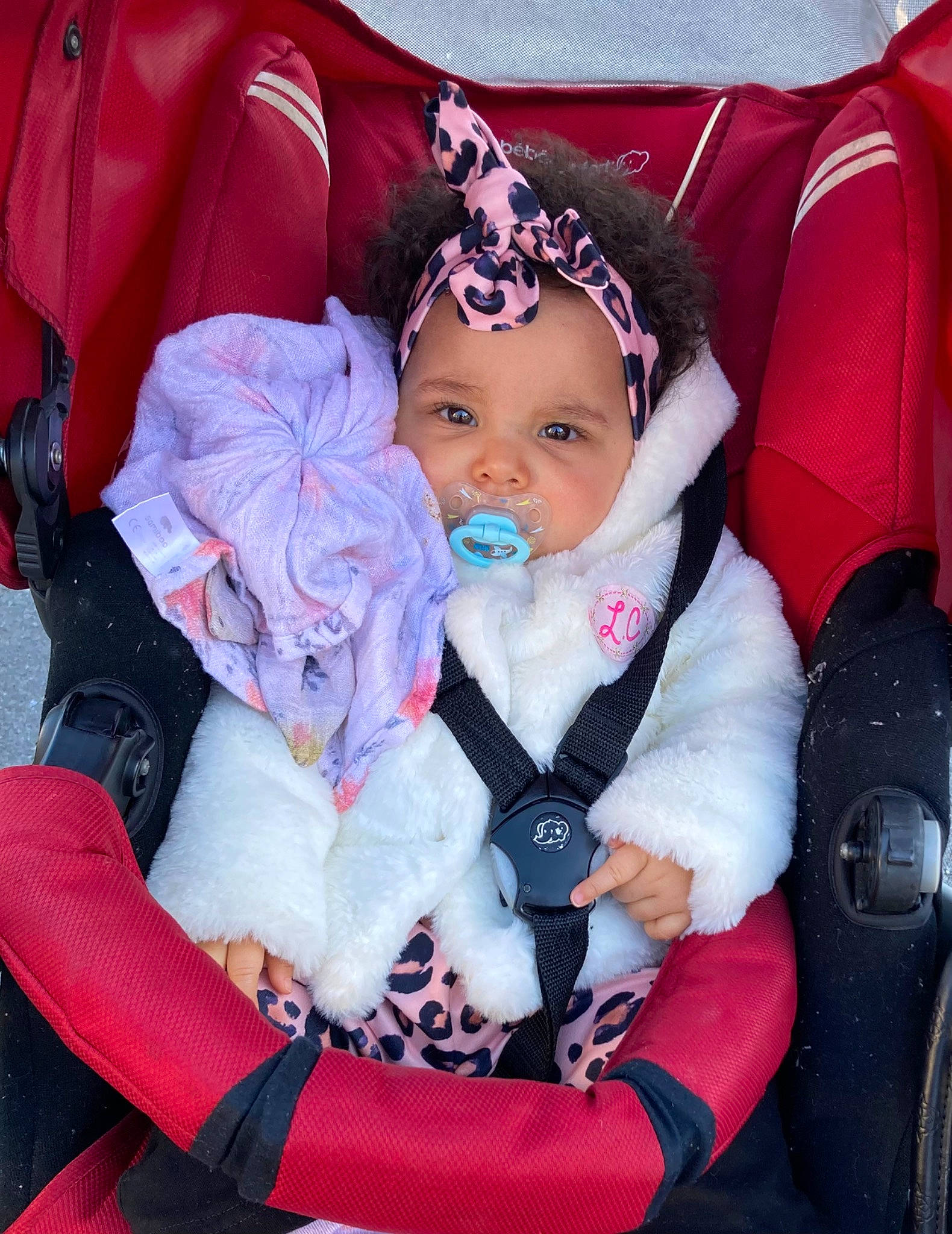 Naleya participe au concours pour gagner de l'argent avec cette photo : baby, baby_carriage, baby_products, baby_toddler_clothing, car_seat, cheek, child, comfort, electric_blue, facial_expression, fashion_accessory, happy, headwear, lap, magenta, person, pink, product, purple, sitting