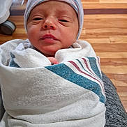 Liam joined the competition — help win amazing prizes! newborn, baby, infant, wrapped, blanket, hat, hospital, floor, wooden_floor, person, face, closeup, indoors, toddler, cute, sleepy, portrait, child, newborn_baby, swaddled