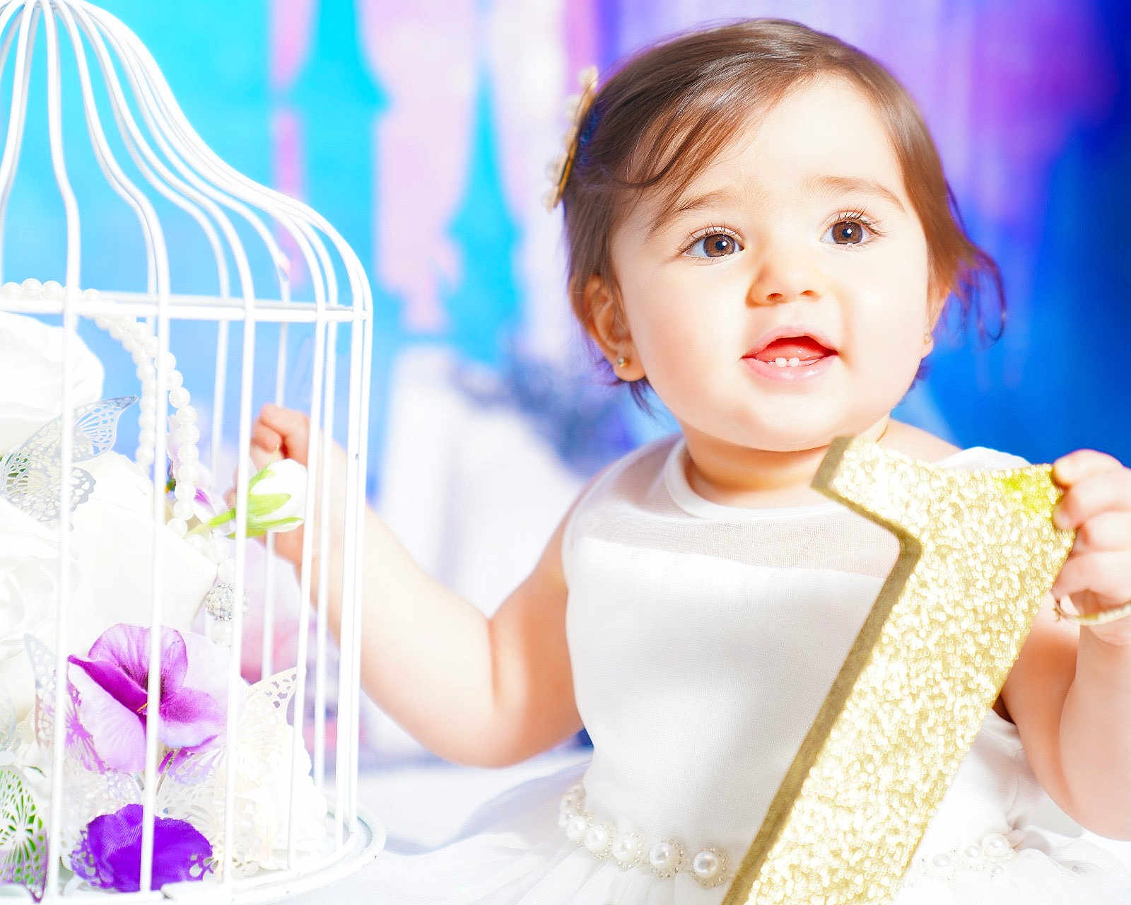 Elaynne joined the competition — help win amazing prizes! baby, child, girl, white_dress, pearls, glitter, number_one, flower, purple_flower, birdcage, decor, portrait, smiling, happy, celebration, indoor, cute, face, hands, bright