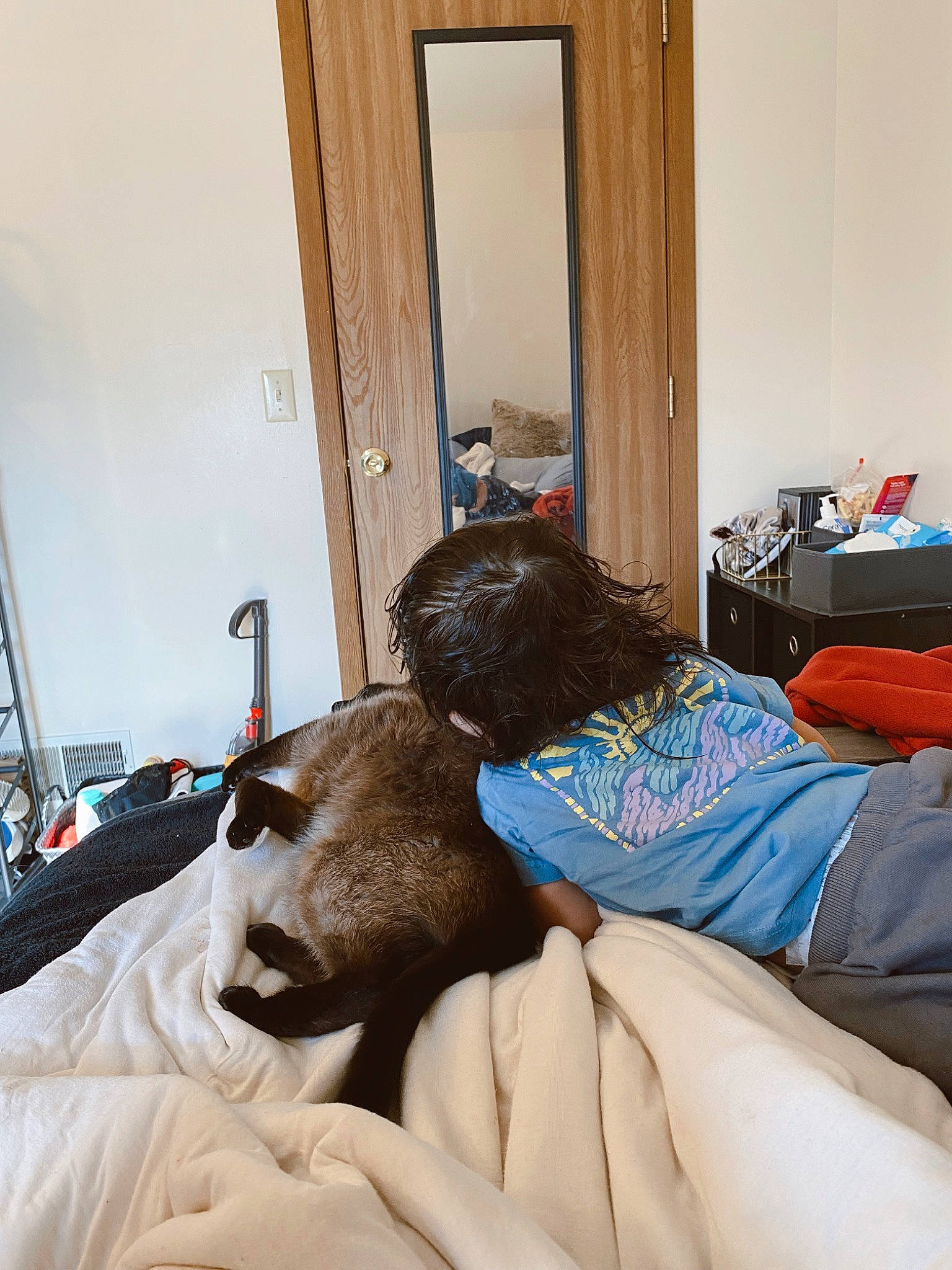 Koa is registered to the contest to win money with this photo: bed, bed_frame, bed_sheet, bedding, bedroom, comfort, door, floor, flooring, hardwood, house, human_leg, interior_design, lamp, leisure, linens, living_room, mirror, person, pillow