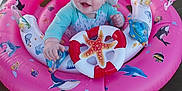Wrenley Rose is registered to the contest to win money with this photo: baby, infant, water, inflatable_ring, pink, hat, smiling, child, floating, summer, outdoor, playful, sea_creatures, canopy, hand, cute, blue_eyes, splash, swimming, fun