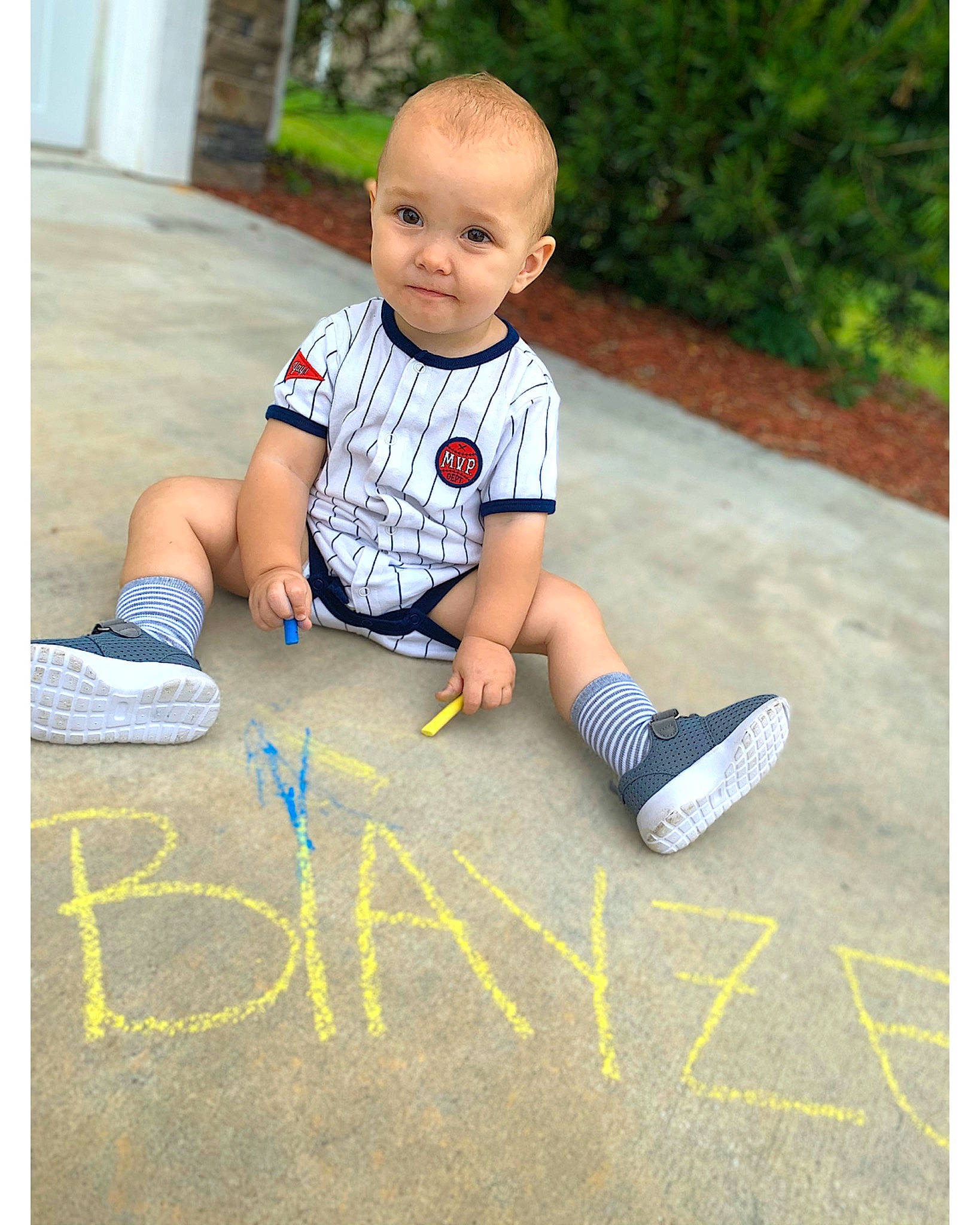 Blayze is registered to the contest to win money with this photo: baby, chalk, child, floor, footwear, person, photography, play, recreation, shoe, sitting, smile, t_shirt, toddler, vacation, yellow