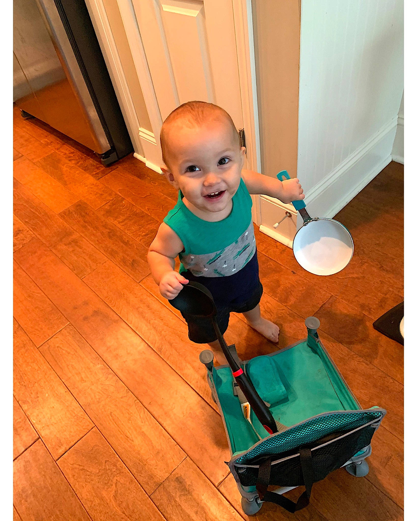 Blayze is registered to the contest to win money with this photo: baby, child, floor, flooring, hardwood, joy, person, play, product, shoe, standing, t_shirt, toddler, turquoise, wood