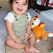 Zeus joined the competition — help win amazing prizes! baby, child, smiling, curly_hair, plush_toy, fox_plush, carpet, sitting, green_leaf_cushion, colorful_toys, indoors, happy, cute, overalls, white_shirt, bracelet, playtime, infant, bright_eyes, cheerful
