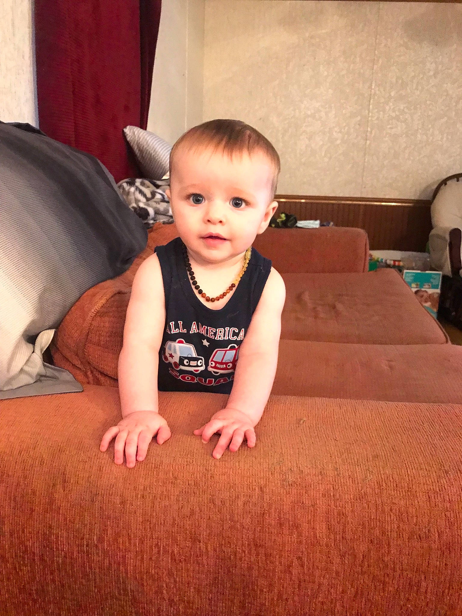 Anthony is registered to the contest to win money with this photo: arm, baby, cheek, child, face, finger, floor, flooring, furniture, head, leg, person, sitting, skin, thumb, toddler