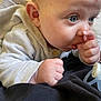 baby, infant, thumb_sucking, blue_eyes, close_up, pacifier, cozy_clothing, cute, child, skin, hand, face, lying_down, indoor, soft_light, newborn, expression, young_child, comfort, curious