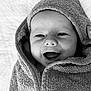 baby, smiling, face, hooded_towel, wrapped, blanket, infant, portrait, happy, cute, child, soft_texture, black_and_white, closeup, laying_down, towel, skin, expression, eyes, mouth