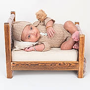 Vardaan joined the competition — help win amazing prizes! baby, child, cozy, cushion, cute, hat, infant, knitted_clothing, looking_at_camera, lying_down, neutral_background, pillow, pom_pom, portrait, relaxed, skin, small_bed, soft_lighting, studio, wooden_bed