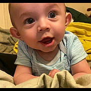 Pierston is registered to the contest to win money with this photo: baby, blanket, blue_shirt, child, closeup, clothing, curiosity, cute, expression, eyes, face, head, indoors, infant, mouth, person, skin, smile, tongue, young