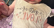 Ryleigh joined the competition — help win amazing prizes! baby, bib, child, infant, purple_clothing, sitting, face, person, indoor, furniture, chair, hand, expression, cute, young_child, human, apparel, skin, closeup, portrait