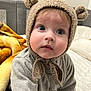 adorable, baby, bear_ears, bed, big_eyes, blanket, blue_eyes, child, closeup, cute, gaze, hat, indoor, infant, knit_hat, portrait, rosy_cheeks, sitting, soft_texture, sweater