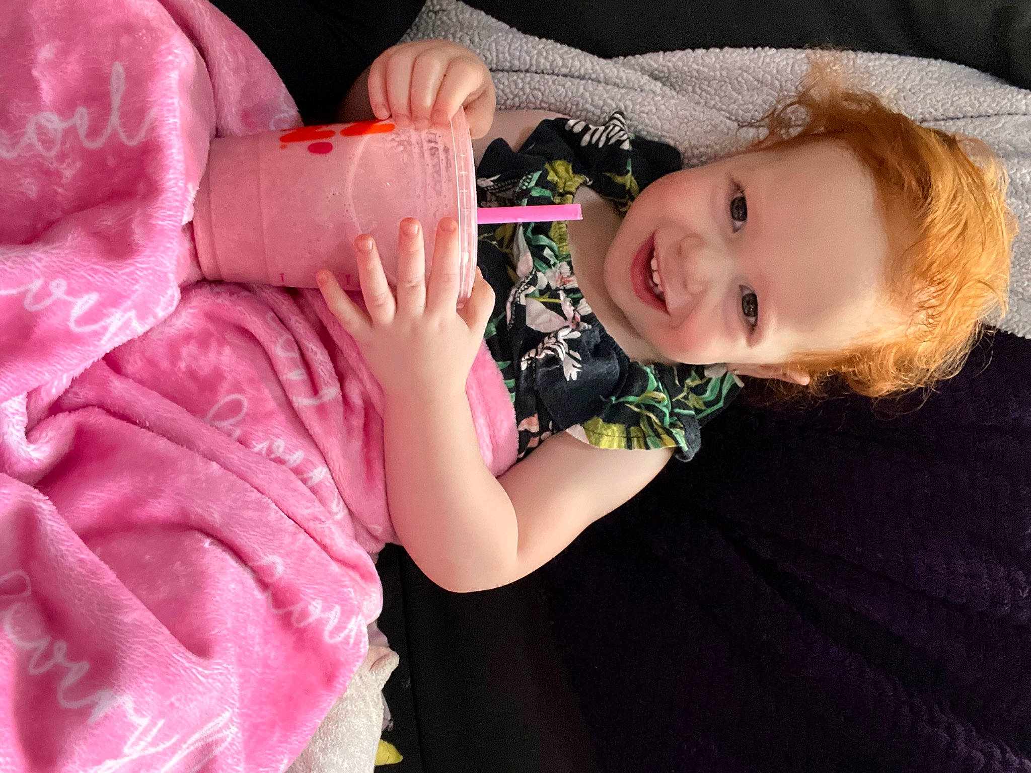 Avery is registered to the contest to win money with this photo: arm, baby, baby_toddler_clothing, cheek, dress, eyelash, finger, gesture, hand, happy, human_body, joy, lip, mouth, nose, person, pink, plant, skin, smile