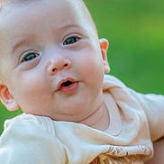Jace is registered to the contest to win money with this photo: baby, infant, child, face, hand, clothing, outdoor, green_background, cute, portrait, skin, expression, holding, person, young, eyes, mouth, short_hair, toddler, shirt