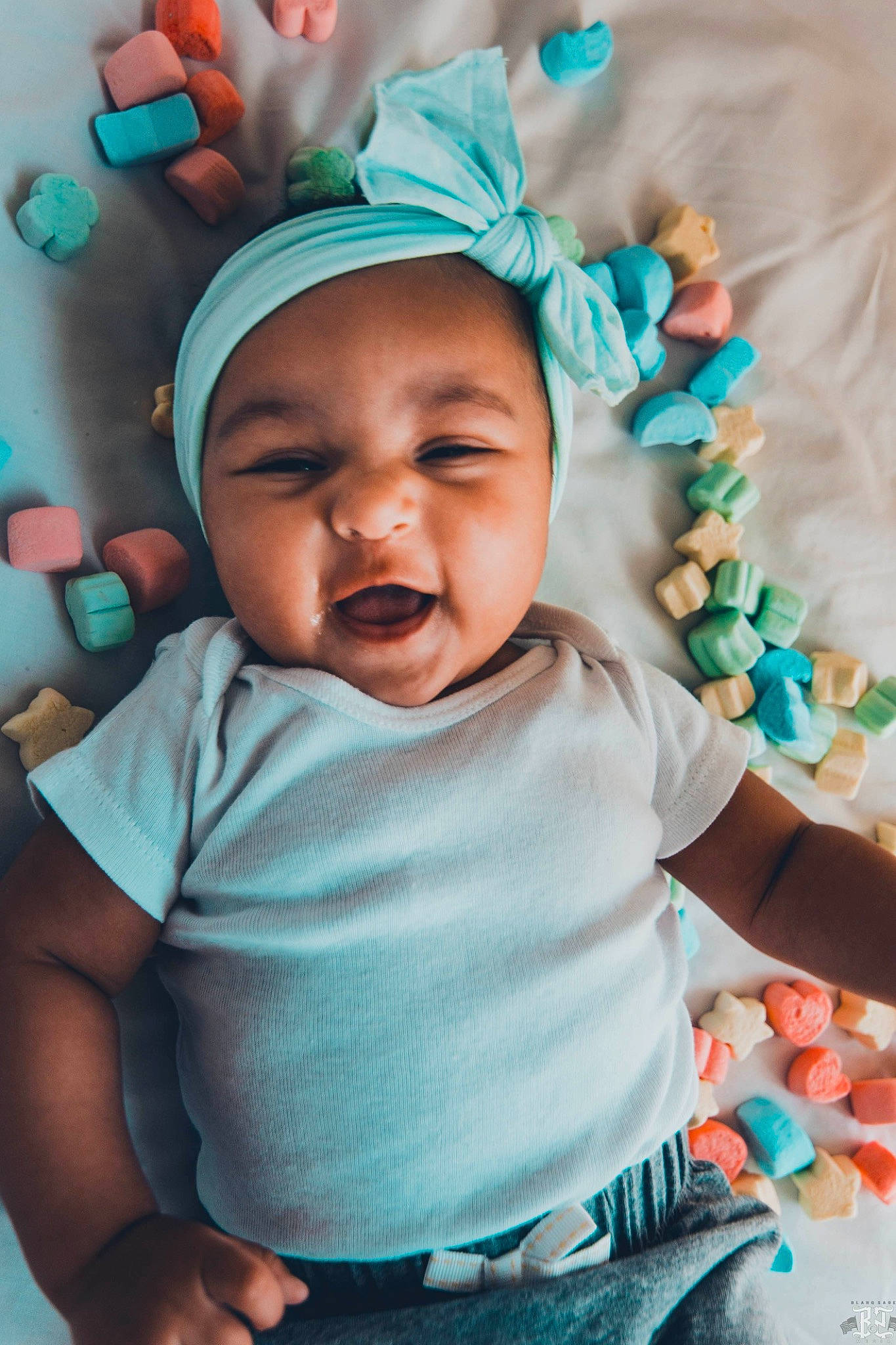 Cordelia is registered to the contest to win money with this photo: baby, cheek, child, facial_expression, fashion_accessory, hair_accessory, happy, head, headgear, headwear, laugh, nose, person, photography, skin, smile, toddler, turquoise