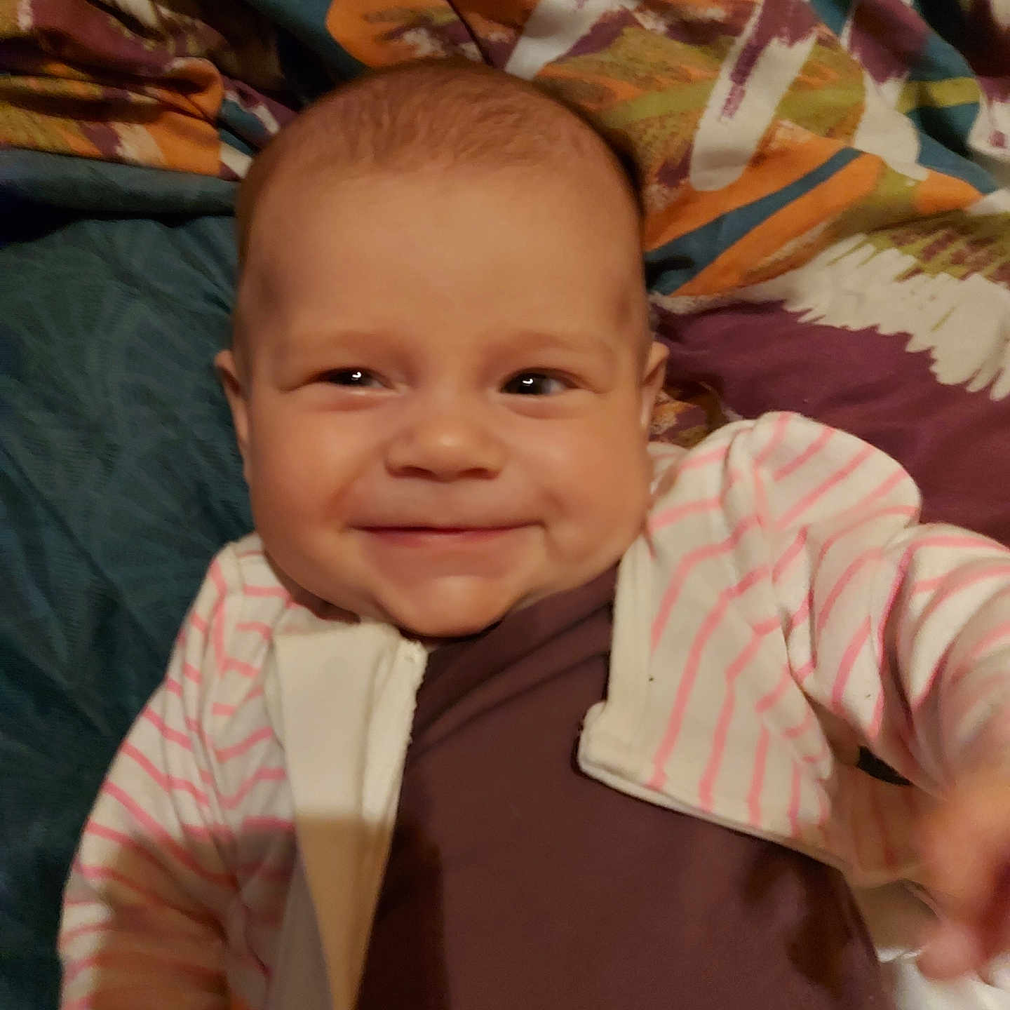 Aimy a rejoint le concours — aidez-le/la à gagner de superbes lots ! baby, blanket, cheeks, child, cute, expression, face, happy, indoors, infant, jacket, lying_down, pattern, person, portrait, small_child, smile, striped_clothing, warm_clothing, young