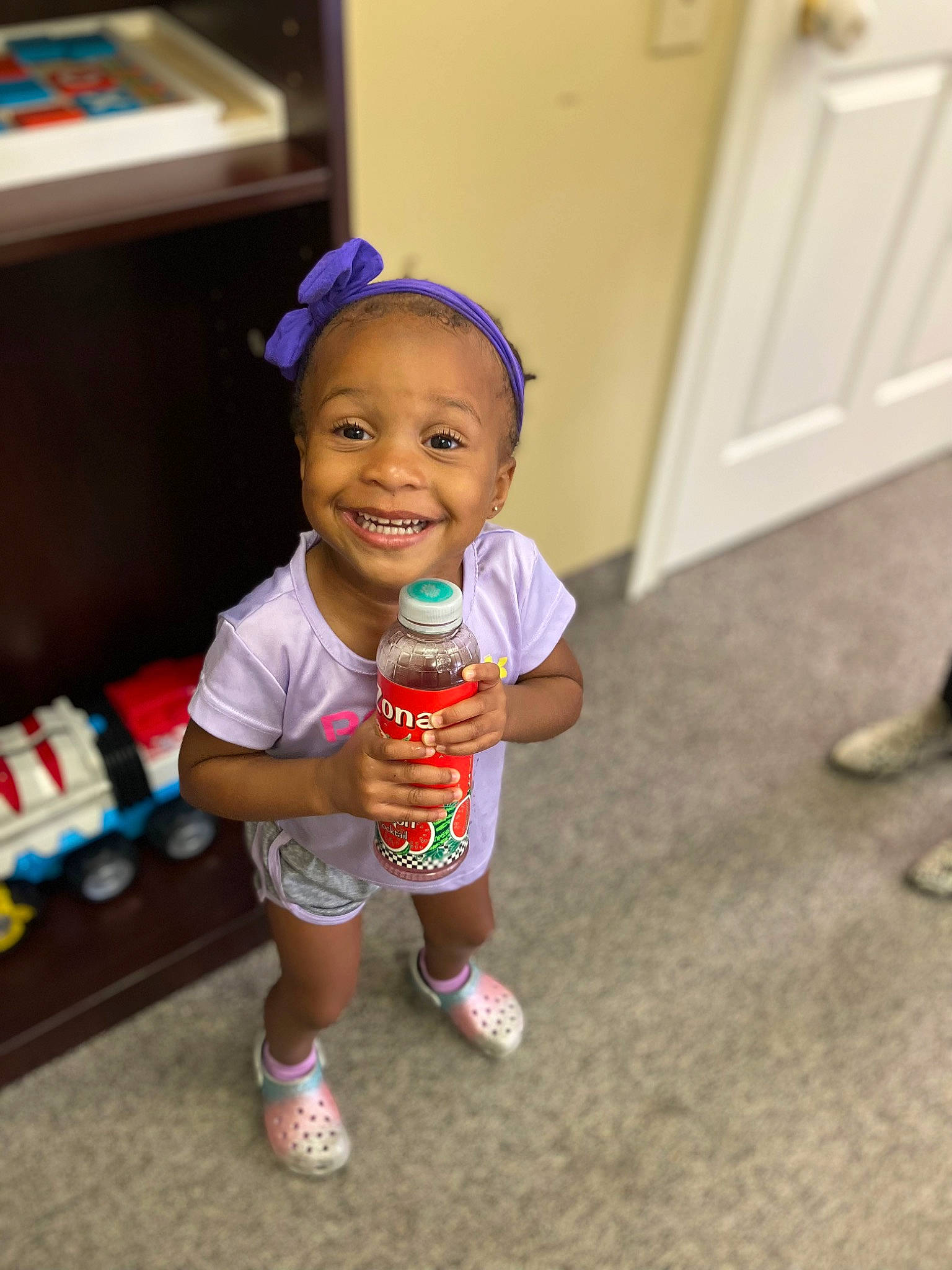 Aubrey is registered to the contest to win money with this photo: baby, baby_toddler_clothing, child, door, event, eye, facial_expression, flooring, fun, happy, human_leg, joy, person, room, shorts, skin, sleeve, smile, sock, thigh