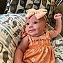 Alena joined the competition — help win amazing prizes! baby, infant, child, smiling, headband, bow, dress, orange, daisy_pattern, pillow, blanket, patterned, cute, indoors, couch, relaxed, happy, skin, arm, portrait