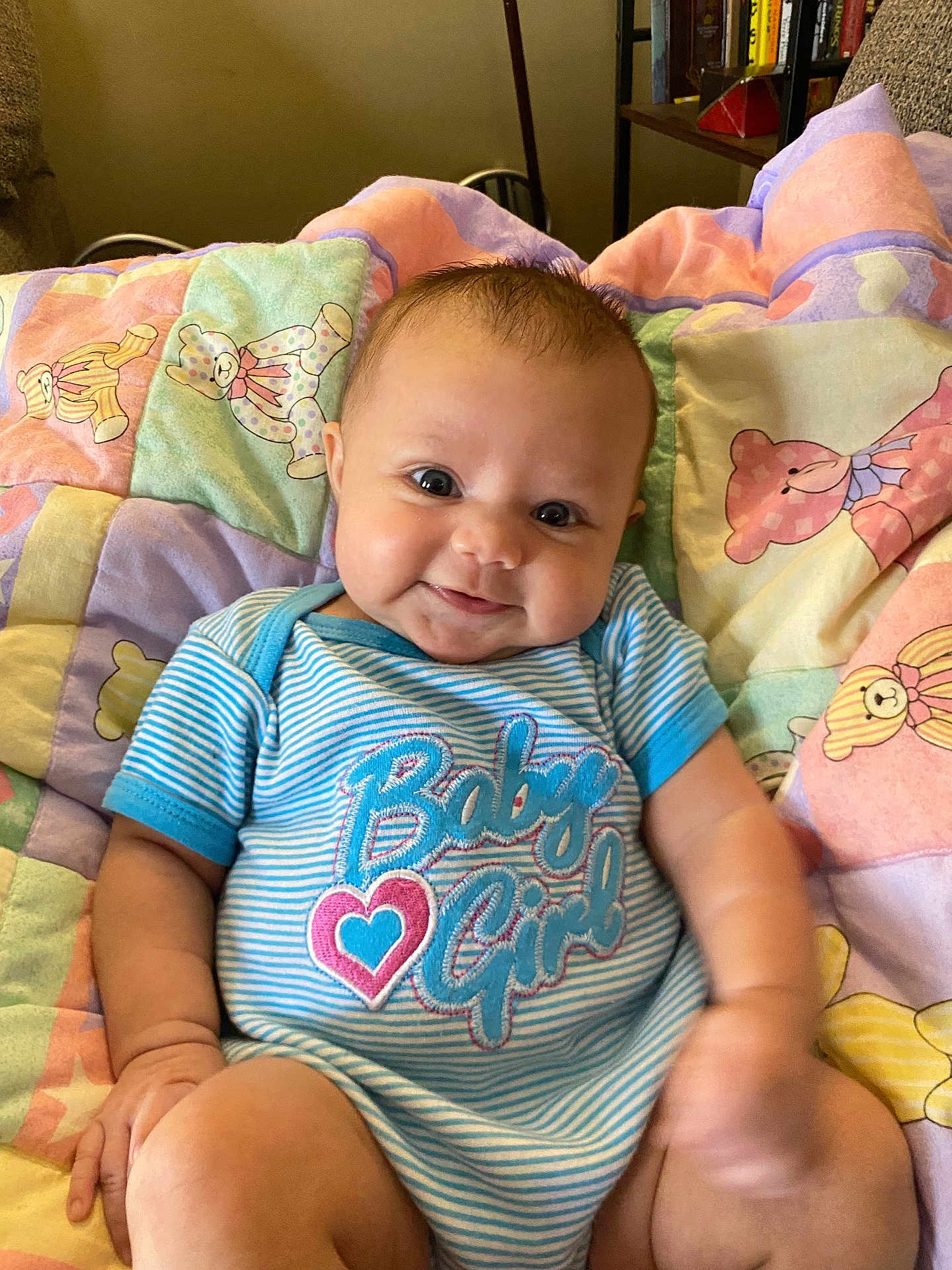 Alena joined the competition — help win amazing prizes! baby, infant, child, smile, onesie, blue_striped_clothing, baby_girl, quilt, patchwork, teddy_bear, cute, happy, sitting, indoor, face, skin, person, young_child, plush, comfort