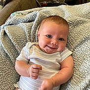 Alena is registered to the contest to win money with this photo: baby, smiling, blanket, infant, cute, indoor, person, clothing, couch, happy, face, head, skin, arm, hand, texture, furniture, relaxing, comfort, portrait