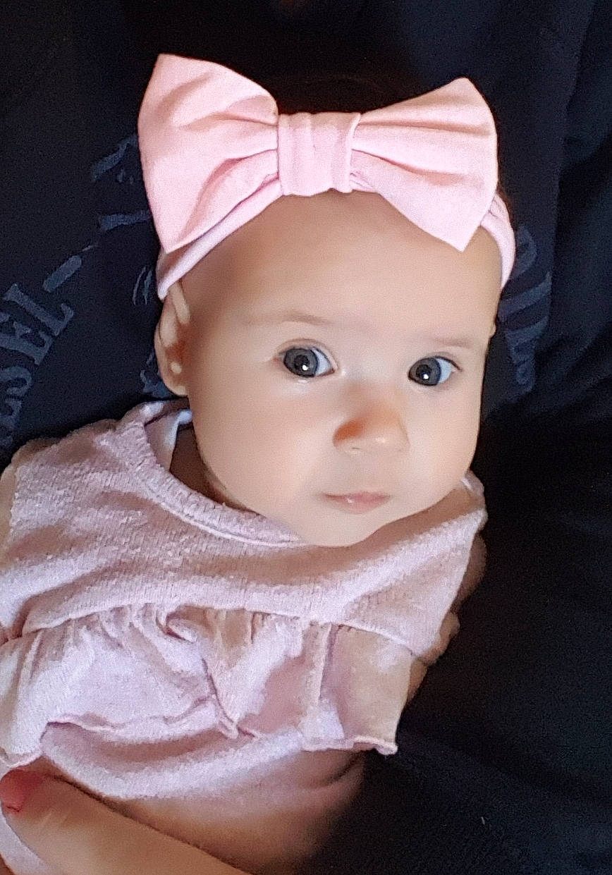 Christine is registered to the contest to win money with this photo: baby, cheek, child, ear, eye, face, hair_accessory, head, headband, headgear, lip, person, pink, skin, toddler