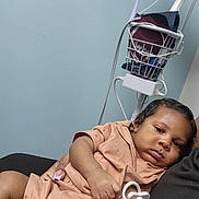 Phaylon joined the competition — help win amazing prizes! baby, infant, child, portrait, sleepy, lying_down, pacifier, caregiver, hospital, medical_monitor, medical_equipment, indoor, seated, brown_clothing, black_clothing, closeup, candid, face, dark_hair, photography