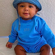 Preston Bradley is registered to the contest to win money with this photo: apparel, baby, blue_clothing, casual, child, cute, denim_hat, face, feet, happy, headwear, indoor, infant, person, portrait, sitting, skin, smiling, socks, young_child