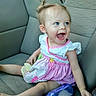 Jocelyn is registered to the contest to win money with this photo: baby, child, toddler, car_seat, dress, pink, white, hair, pony_tail, blue_eyes, smile, laughing, bottle, sitting, cute, infant, happy, clothing, indoor, person