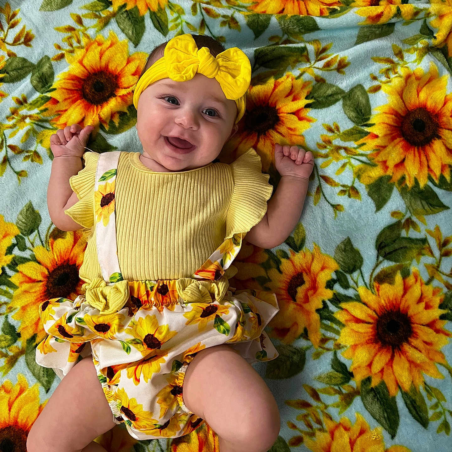 Delilah is registered to the contest to win money with this photo: baby, clothing, daisy, face, flower, flowerarrangement, flowerbouquet, happy, hat, head, herbal, herbs, leaf, person, petal, photography, plant, portrait, smile, sunflower