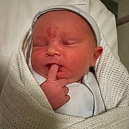 Jacob is registered to the contest to win money with this photo: newborn, baby, infant, sleeping, wrapped, blanket, white, knitted, finger, hat, cute, peaceful, indoors, bed, soft, portrait, child, person, newborn_clothing, gentle