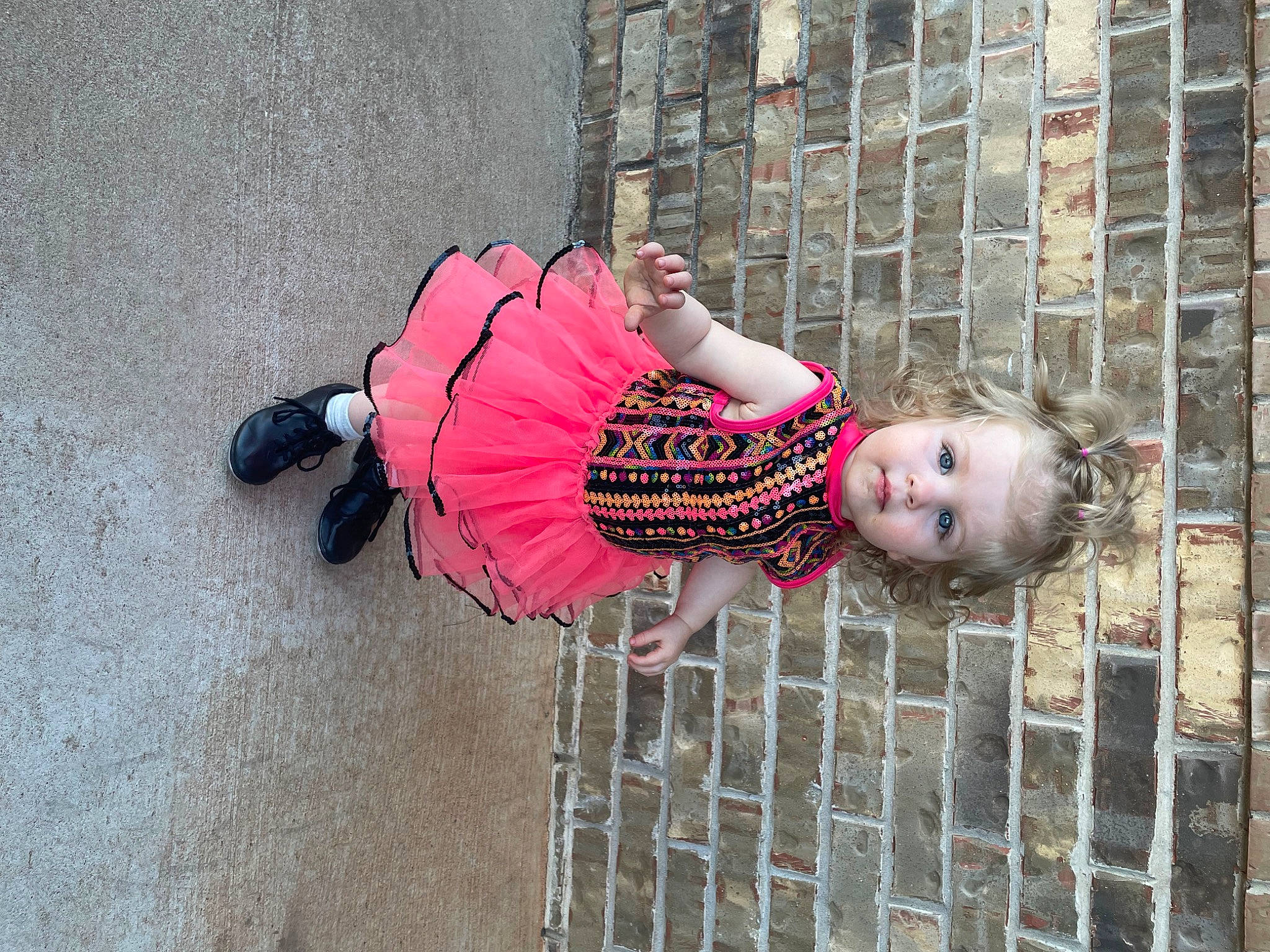 Abigail is registered to the contest to win money with this photo: baby, baby_toddler_clothing, child, clothing, concrete, fence, flooring, fun, happy, human_leg, magenta, metal, pattern, person, pink, red, road_surface, sitting, smile, toddler