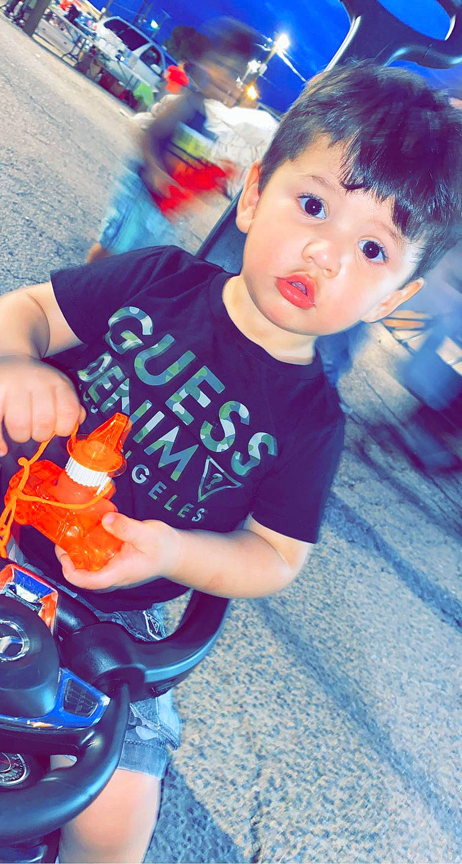 Jesus is registered to the contest to win money with this photo: automotive_lighting, baby_toddler_clothing, beauty, blue, child, cool, electric_blue, finger, fun, happy, head, leisure, person, play, recreation, sitting, sleeve, t_shirt, toddler, toy