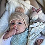 baby, infant, hat, knit_hat, pom_pom, blanket, stuffed_animal, bunny, toy, thumb_sucking, blue_eyes, scarf, soft_texture, close_up, indoor, cute, cozy, child, sleepy, warm