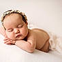 baby, calm, child, closed_eyes, cute, face, flower_headband, hands, infant, napping, newborn, peaceful, portrait, resting, skin, sleeping, soft_lighting, soft_texture, tender, white_background