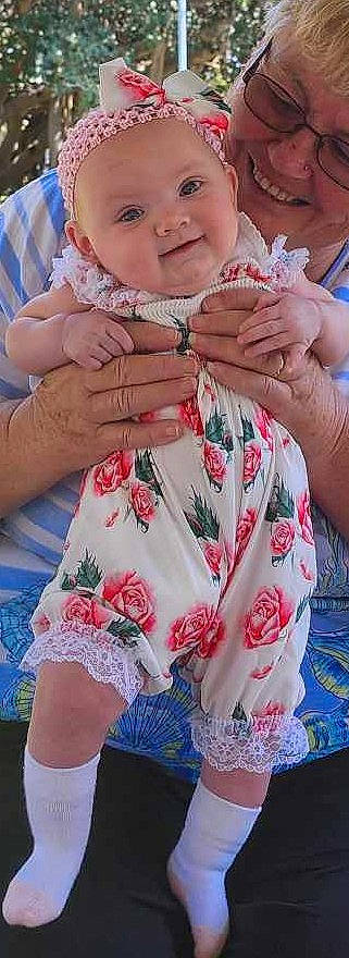Aryah is registered to the contest to win money with this photo: arm, baby, baby_toddler_clothing, dress, finger, gesture, hand, happy, joy, lip, nail, neck, organ, person, pink, skin, sleeve, smile, textile, thigh