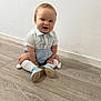 Christopher joined the competition — help win amazing prizes! baby, child, smiling, sitting, floor, white_wall, wooden_floor, blue_shorts, white_shirt, knee_socks, pom_poms, blue_shoes, happy, indoors, cute, portrait, person, infant, young_child, casual_clothing