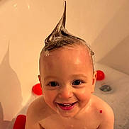 Hailey is registered to the contest to win money with this photo: toddler, child, bath, bubbles, shampoo, hair_spike, smile, happy, water, skin, toy, red, playful, cute, face, indoors, bathroom, head, childhood, fun