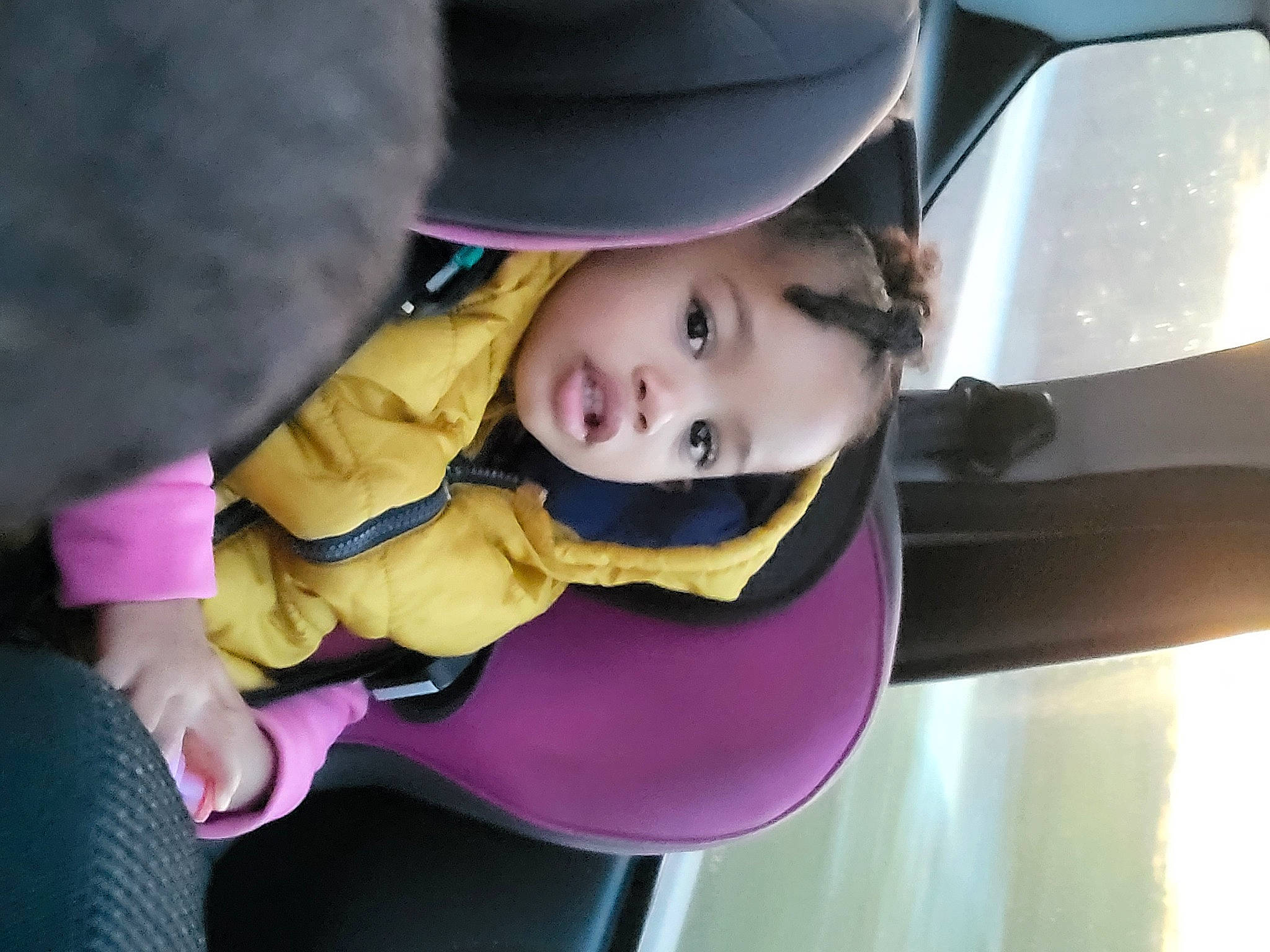 Inaya a rejoint le concours — aidez-le/la à gagner de superbes lots ! auto_part, automotive_exterior, automotive_lighting, baby, baby_products, baby_toddler_clothing, car_seat, cheek, child, fashion_accessory, fun, hat, person, pink, purple, sitting, smile, toddler, tree, vehicle_door