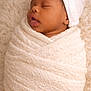 Makai Dior is registered to the contest to win money with this photo: baby, blanket, child, closeup, cozy, cute, headwear, indoors, infant, knitted, newborn, peaceful, portrait, resting, skin, sleeping, soft_texture, warm, white_hat, wrapped