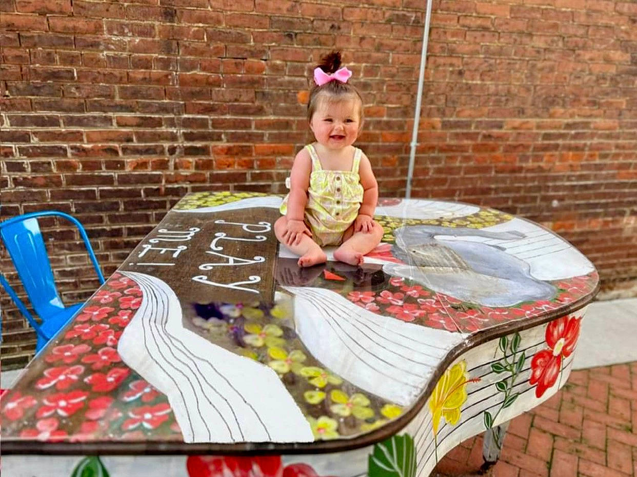 Everleigh joined the competition — help win amazing prizes! baby, brick, brickwork, child, city, event, fun, grass, joy, leisure, linens, outdoor_furniture, pattern, person, pink, recreation, sidewalk, sitting, toddler, vacation