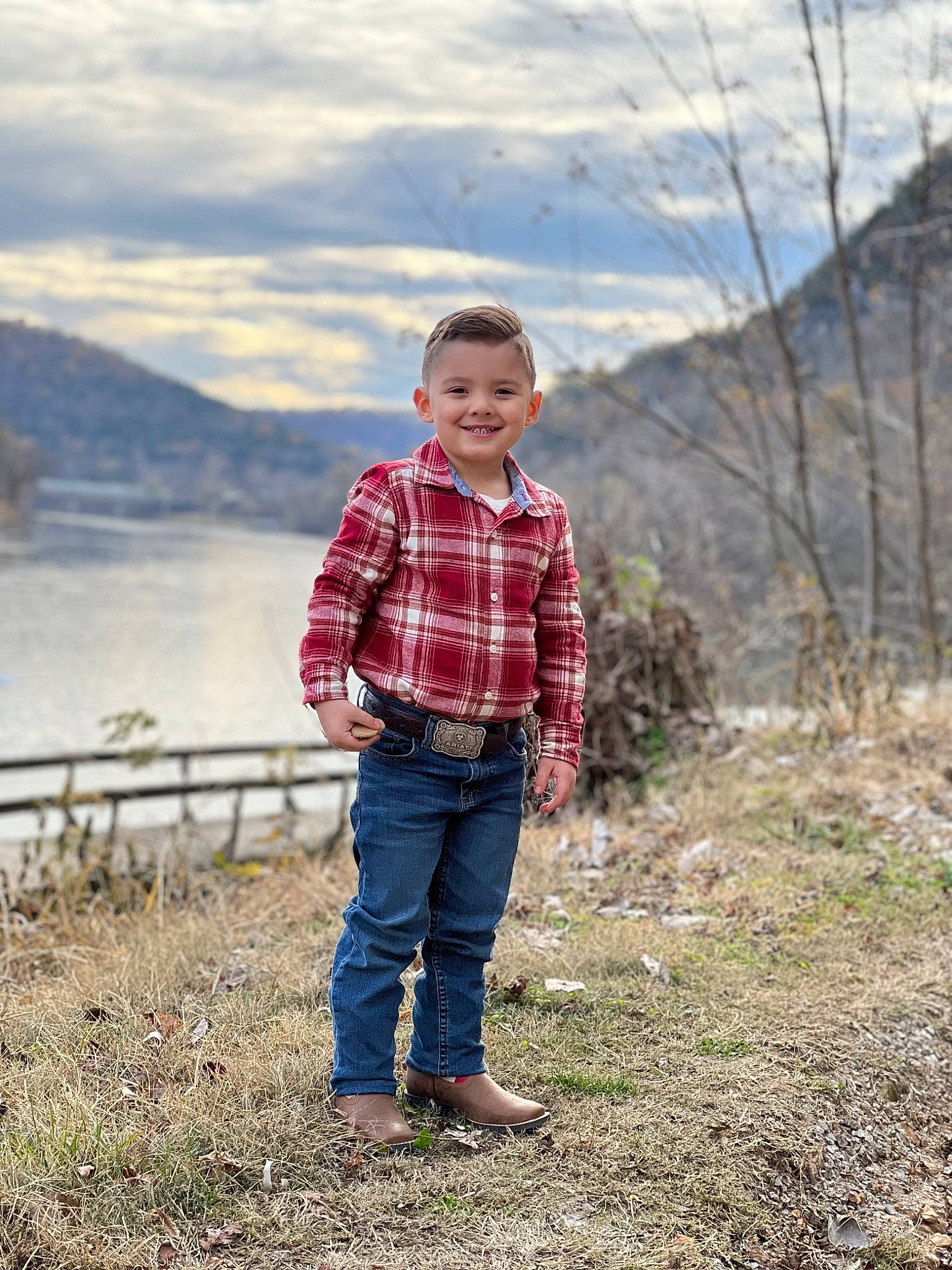 Colton is registered to the contest to win money with this photo: cloud, fence, fun, grass, grassland, happy, joy, lake, landscape, leisure, mountain, pattern, people_in_nature, person, plaid, plant, sky, tartan, tree, water