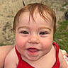 Bailey is registered to the contest to win money with this photo: baby, child, infant, portrait, smiling, happy, outdoor, red_outfit, sitting, face, eyes, hair, cheeks, tongue, close_up, person, playful, daylight, sandy_ground, photography