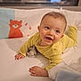 baby, bed, blanket, cheerful, child, cozy, cute, cute_animal, face, happy, indoor, infant, lying_down, orange_fox, plush_toy, portrait, smiling, soft_toys, yellow_onesie, young_child