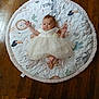 Tellisa is registered to the contest to win money with this photo: baby, infant, dress, play_mat, animal_pattern, floor, wooden_floor, feet, colorful_pants, child, cute, lying_down, indoors, person, smiling, white_dress, soft_mat, decor, home, small_child