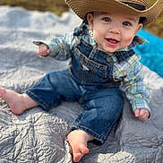 Elias is registered to the contest to win money with this photo: baby, bodypart, cap, clothing, cowboyhat, dress, face, finger, hand, happy, hat, head, jeans, pants, person, photography, portrait, quilt, sitting, sunhat