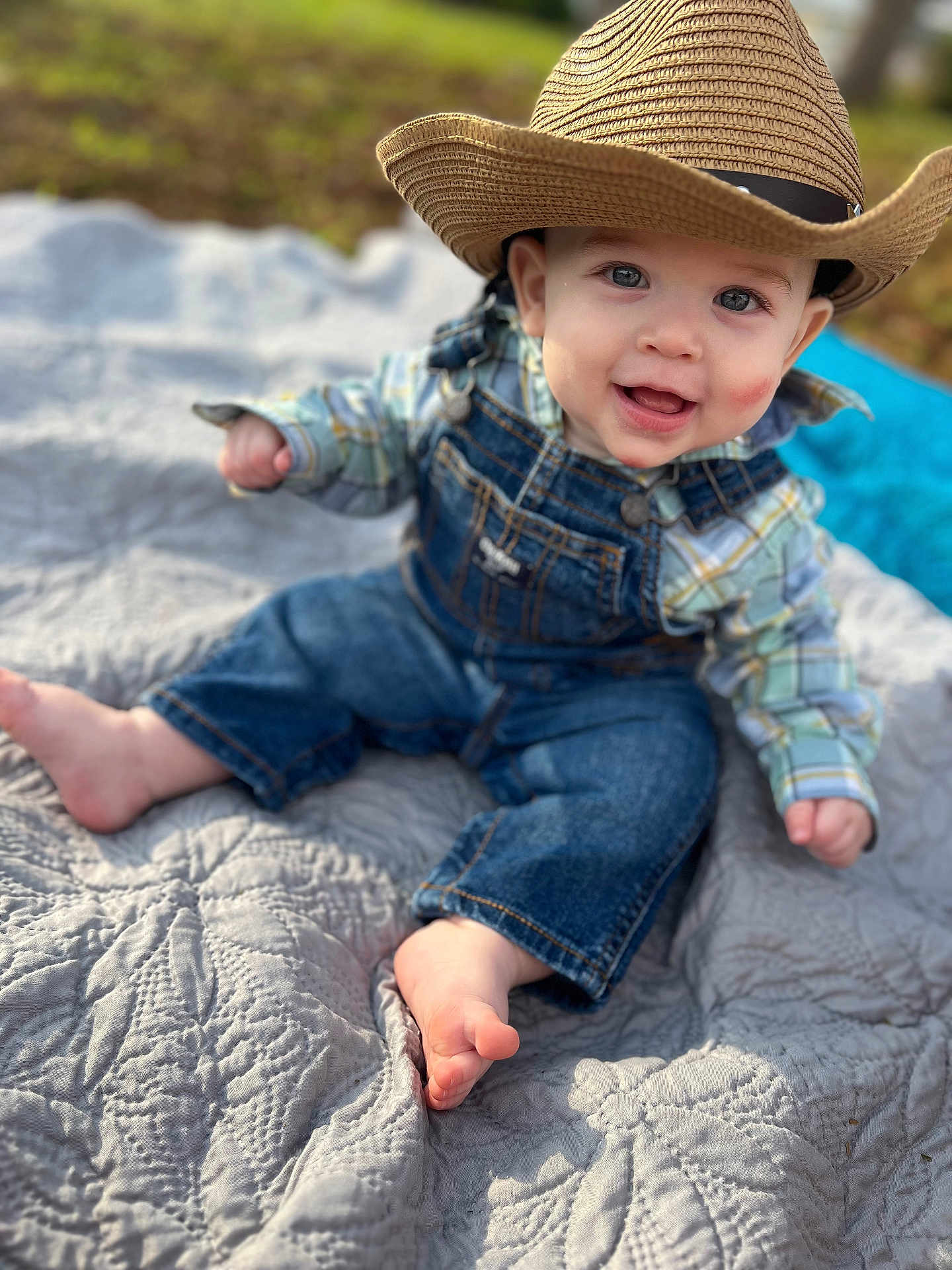 Elias is registered to the contest to win money with this photo: baby, bodypart, cap, clothing, cowboyhat, dress, face, finger, hand, happy, hat, head, jeans, pants, person, photography, portrait, quilt, sitting, sunhat