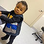 Messiah joined the competition — help win amazing prizes! toddler, child, indoor, curious, vest, black_clothing, standing, chair, floor, door, office_chair, portrait, person, young_child, footwear, looking, expression, casual, hair, skin